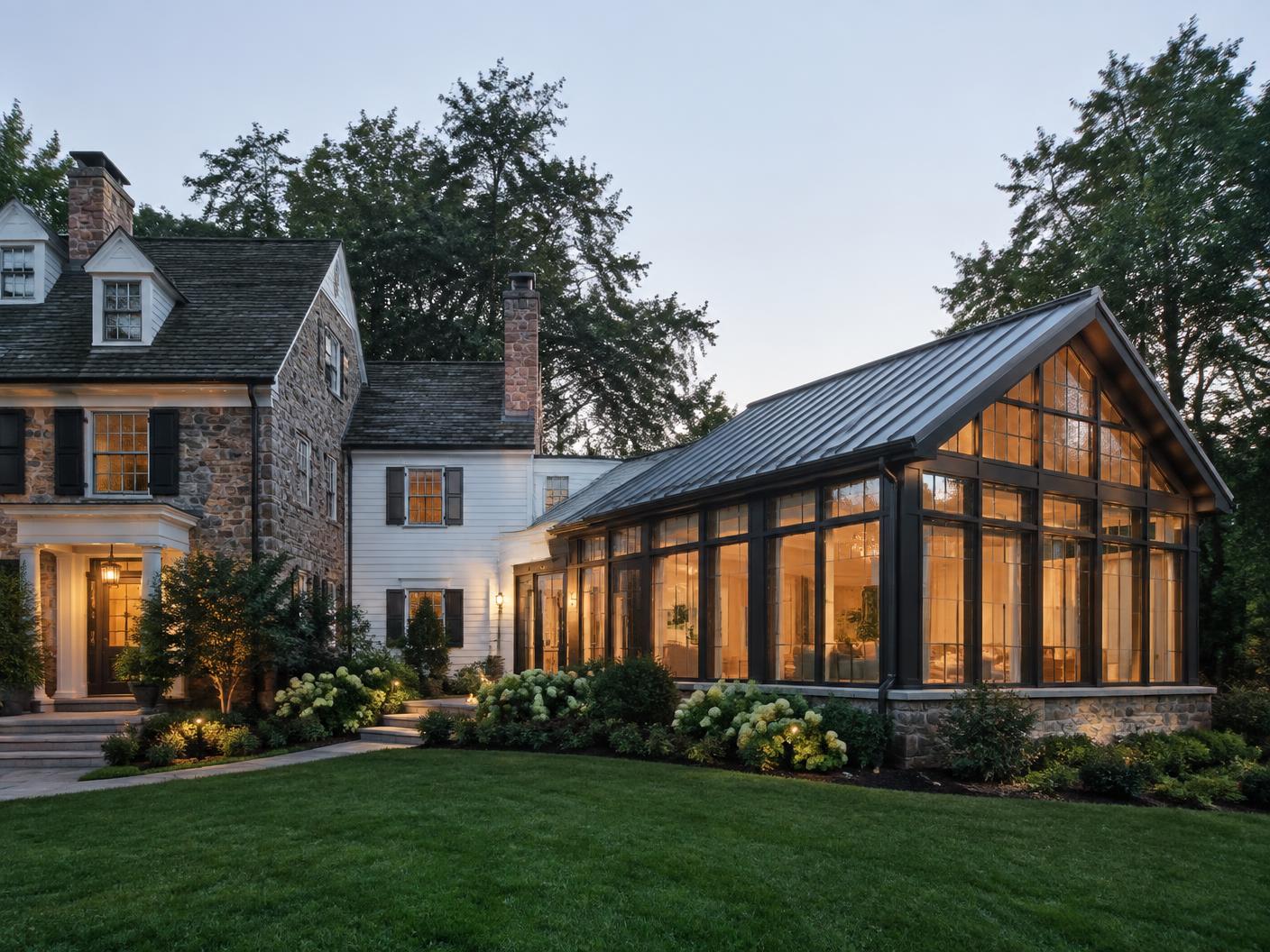 Glass sunroom addition attached to a classic stone colonial home